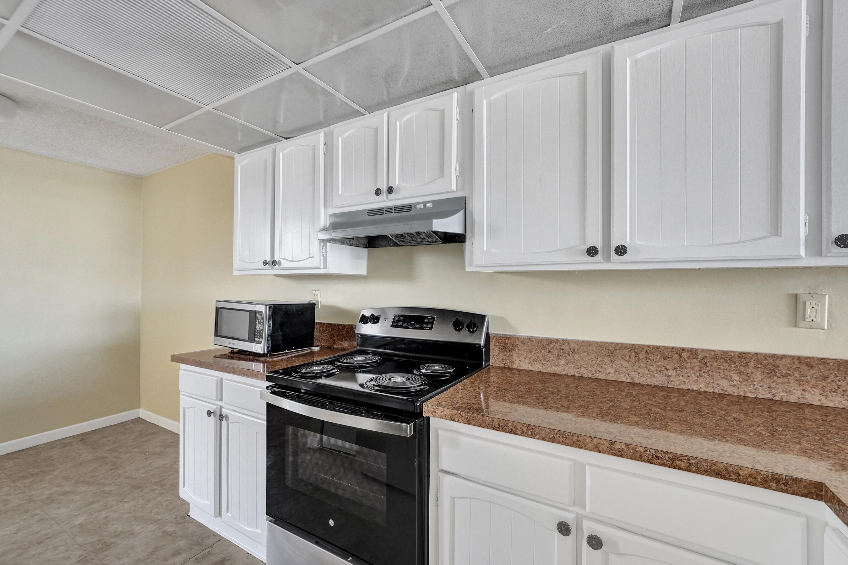 12 Royal Palm Way, Unit 6020 Boca Raton, FL 33432 - Photo 62 of 69 a kitchen with granite countertop white cabinets and stainless steel appliances