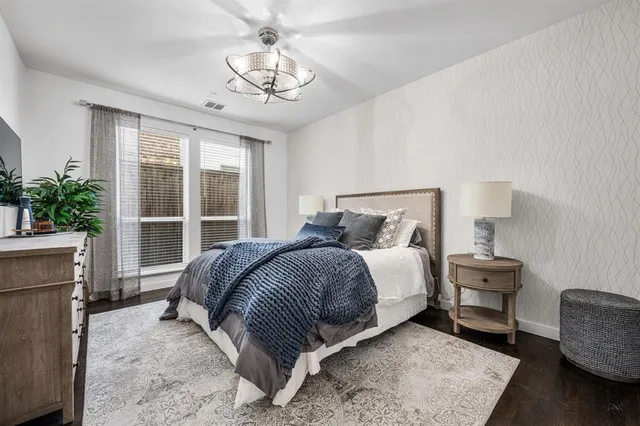 a bedroom with a large bed and a chandelier
