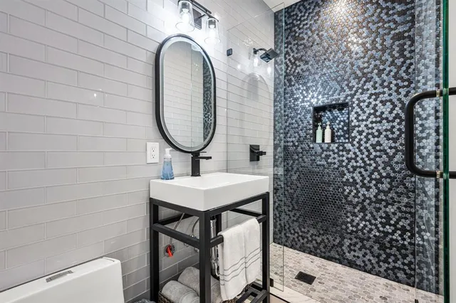 a bathroom with a sink a toilet and shower