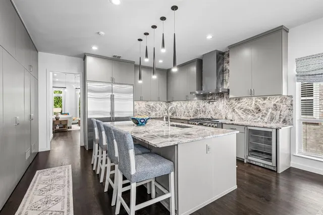 a kitchen with stainless steel appliances kitchen island a stove a sink a oven a dining table and chairs