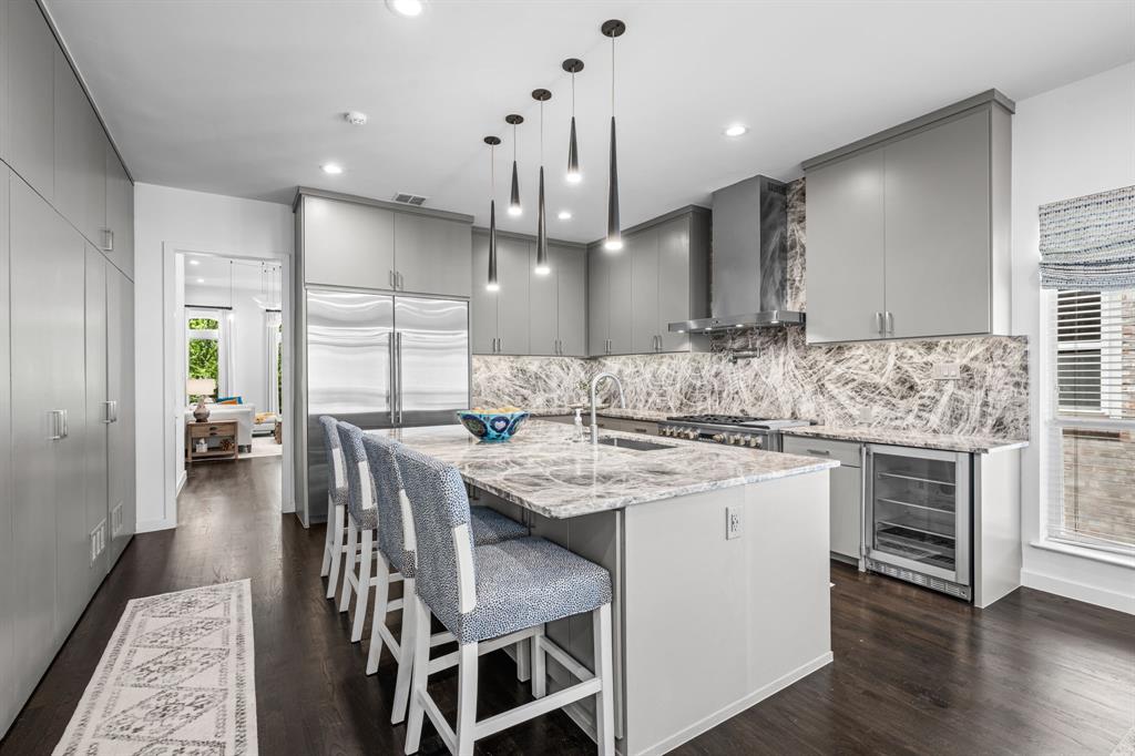 2214 Allen Street, Unit A Dallas, TX 75204 - Photo 17 of 36 a kitchen with stainless steel appliances kitchen island a stove a sink a oven a dining table and chairs