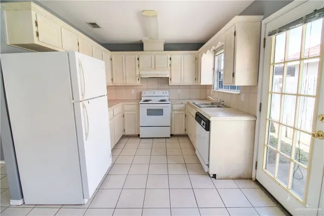 a kitchen with a white stove top oven and refrigerator