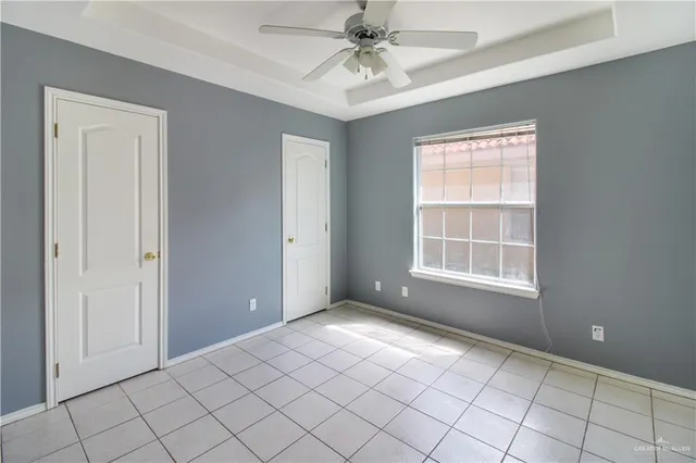 an empty room with windows and fan