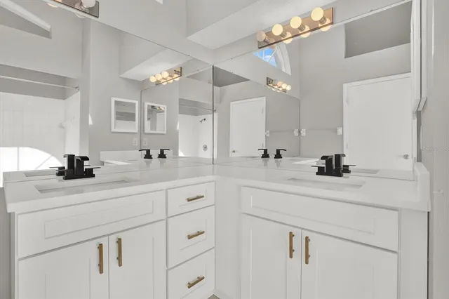 a bathroom with a sink vanity granite and a mirror