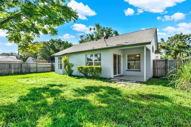 a view of a house with a yard and potted plants