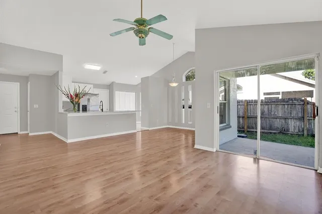 a view of an empty room with window and wooden floor