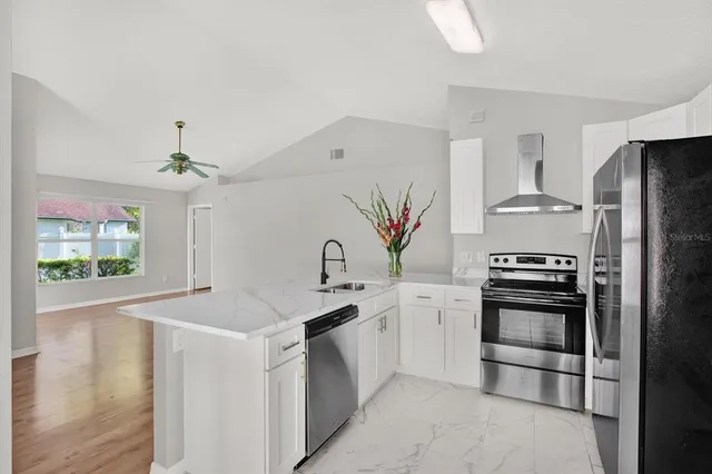 a kitchen with stainless steel appliances a stove a sink and a refrigerator