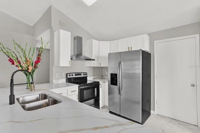 a kitchen with stainless steel appliances a refrigerator sink and cabinets