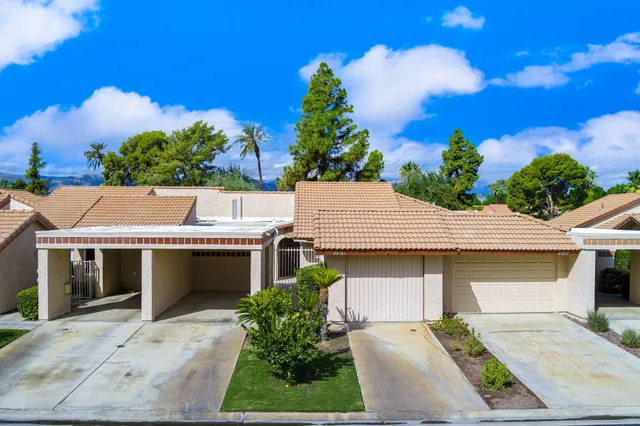 a front view of a house with a garden and plants