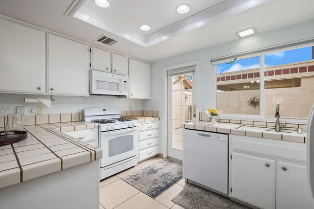 a kitchen with cabinets appliances a sink and a window