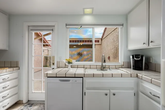 a kitchen with stainless steel appliances granite countertop a sink and a refrigerator