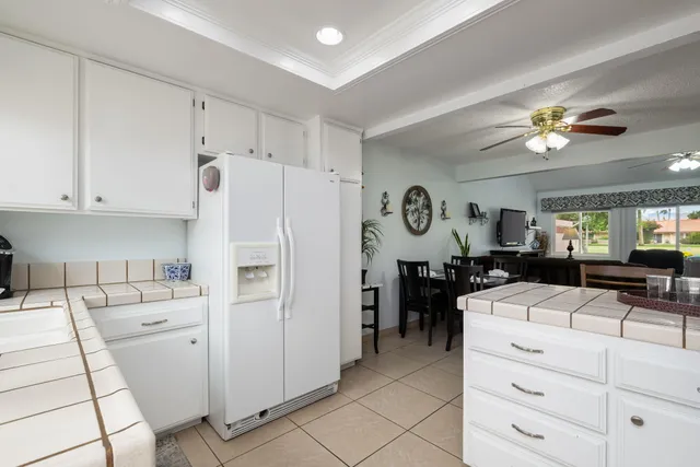 a kitchen with a refrigerator a stove a dining table and chairs