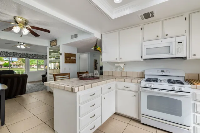 a kitchen with white cabinets and white appliances