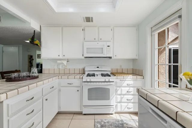 a kitchen with cabinets appliances a sink and a counter top space