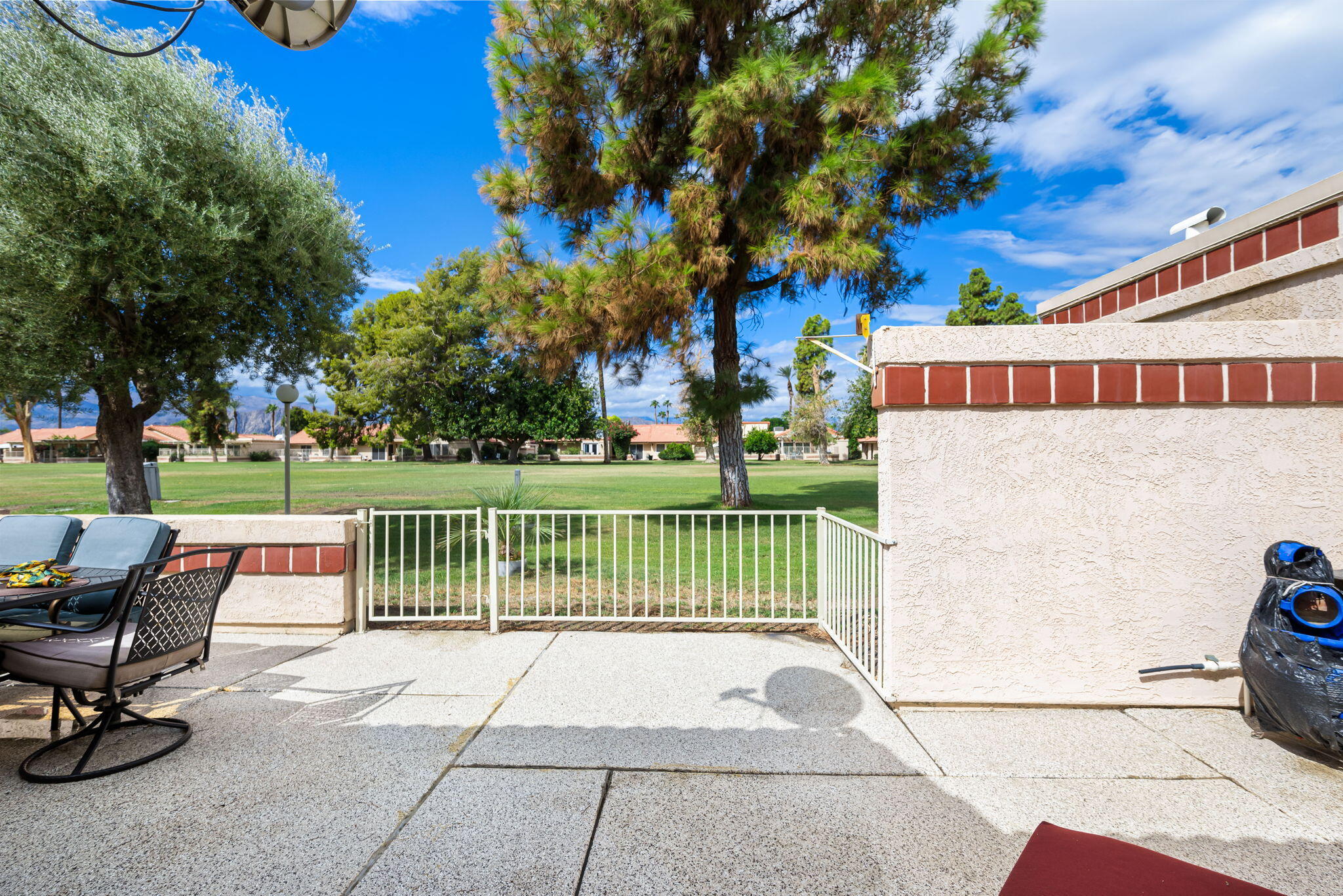 49101 Taylor Street Indio, CA 92201 - Photo 37 of 47 a view of a patio with a table and chairs and a fire pit