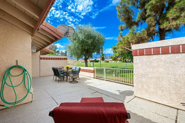 a view of a patio with table and chairs with wooden fence and plants