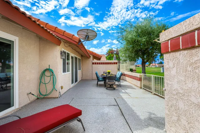 a view of a chairs and table in the back yard of the house