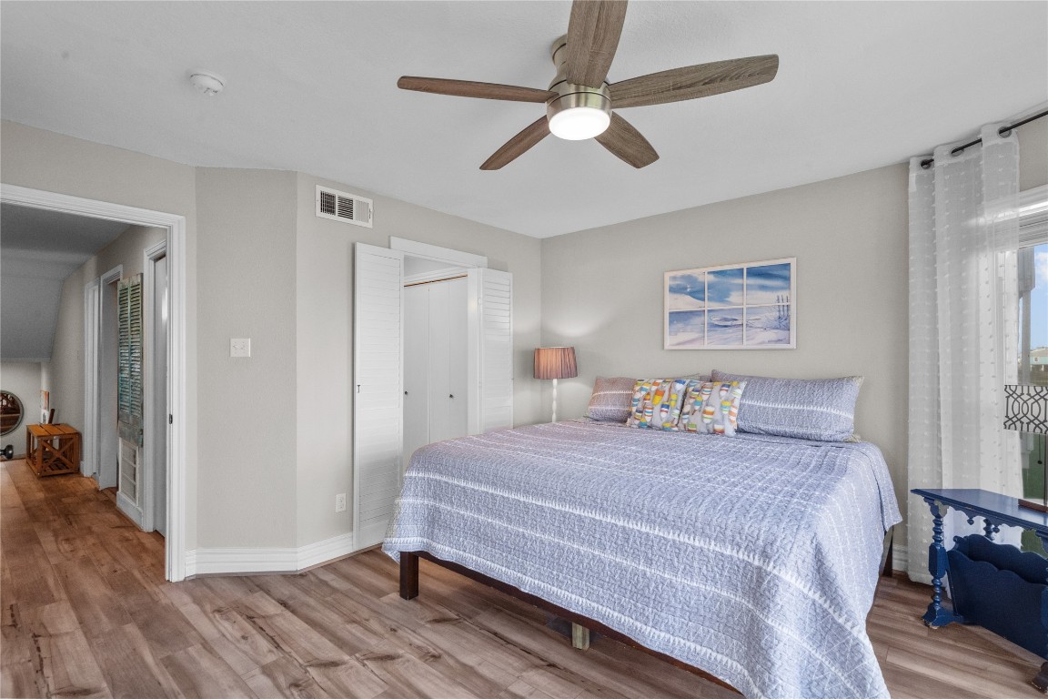 17729 Termini-San Luis Pass Road Galveston, TX 77554 - Photo 18 of 36 a bedroom with a bed and a chandelier