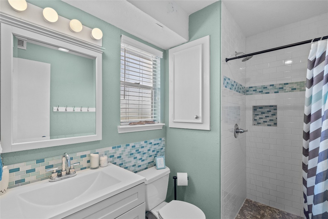 17729 Termini-San Luis Pass Road Galveston, TX 77554 - Photo 26 of 36 a bathroom with a sink vanity granite toilet and a mirror