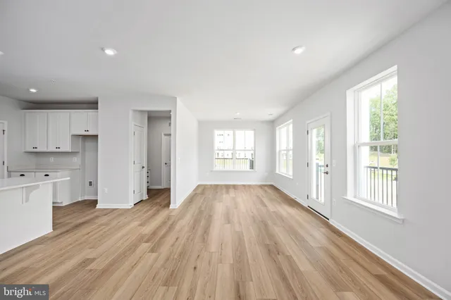 a view of kitchen with kitchen island white cabinets and stainless steel appliances
