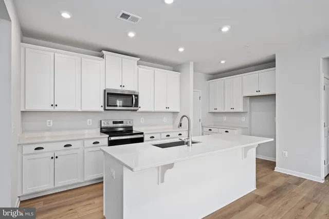 a kitchen with cabinets and wooden floor