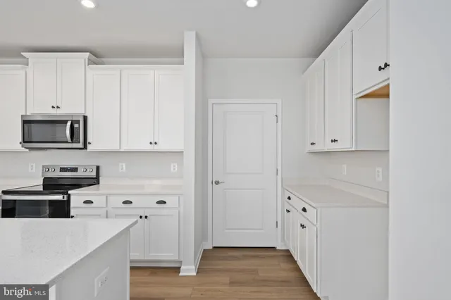 a kitchen with stainless steel appliances granite countertop a sink dishwasher stove top oven and cabinets with wooden floor