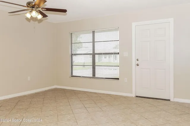 an empty room with a window and a fan