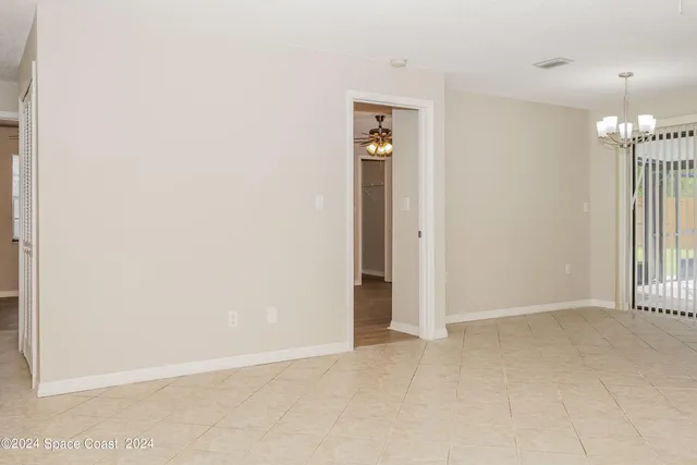 an empty room with stairs and entrance to other room