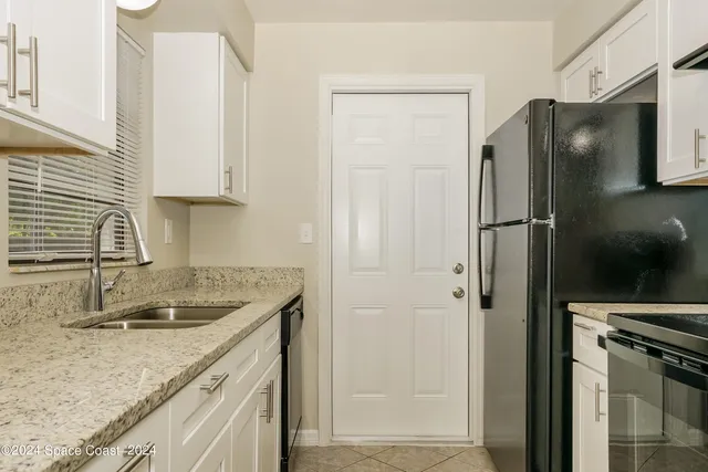 a kitchen with stainless steel appliances granite countertop a refrigerator and a sink