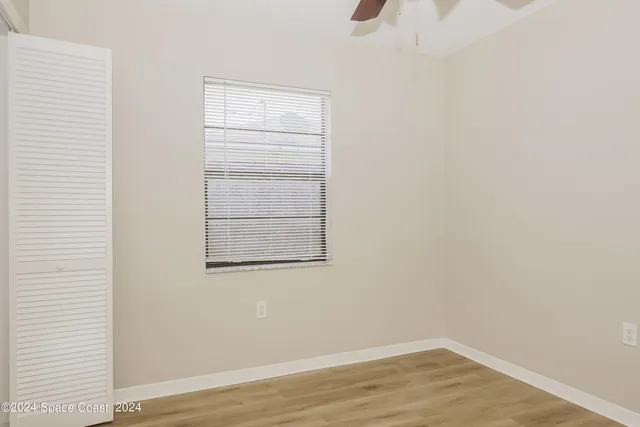 a view of a small space with wooden floor and a window