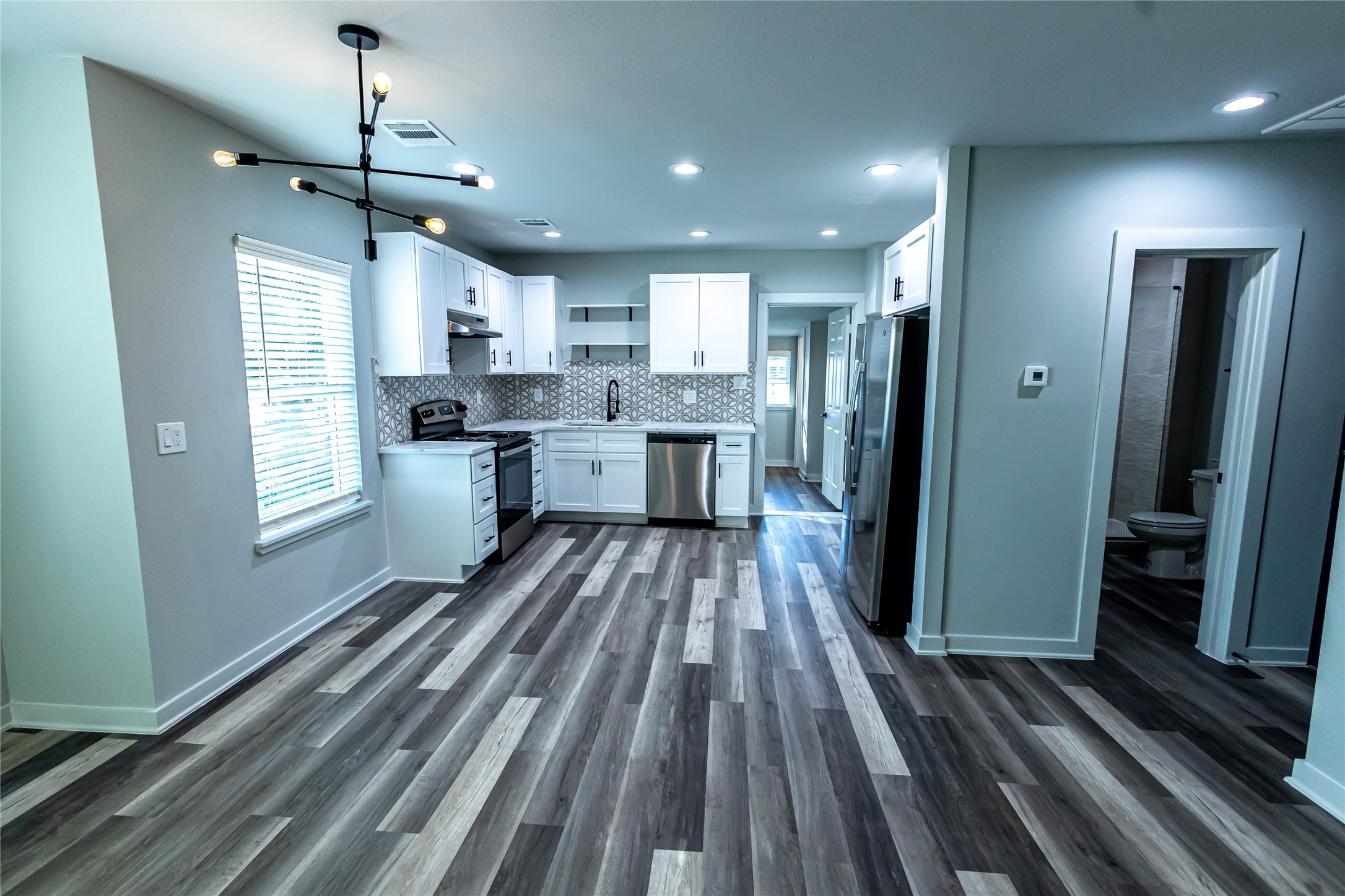 102 Marsden Street, Unit 4 Houston, TX 77011 - Photo 15 of 26 a open kitchen with kitchen island wooden floor center island and stainless steel appliances