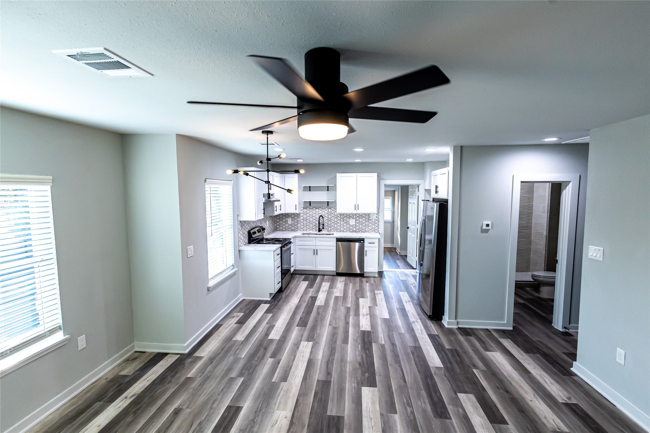 102 Marsden Street, Unit 4 Houston, TX 77011 - Photo 24 of 26 a view of a living room with wooden floor and a ceiling fan