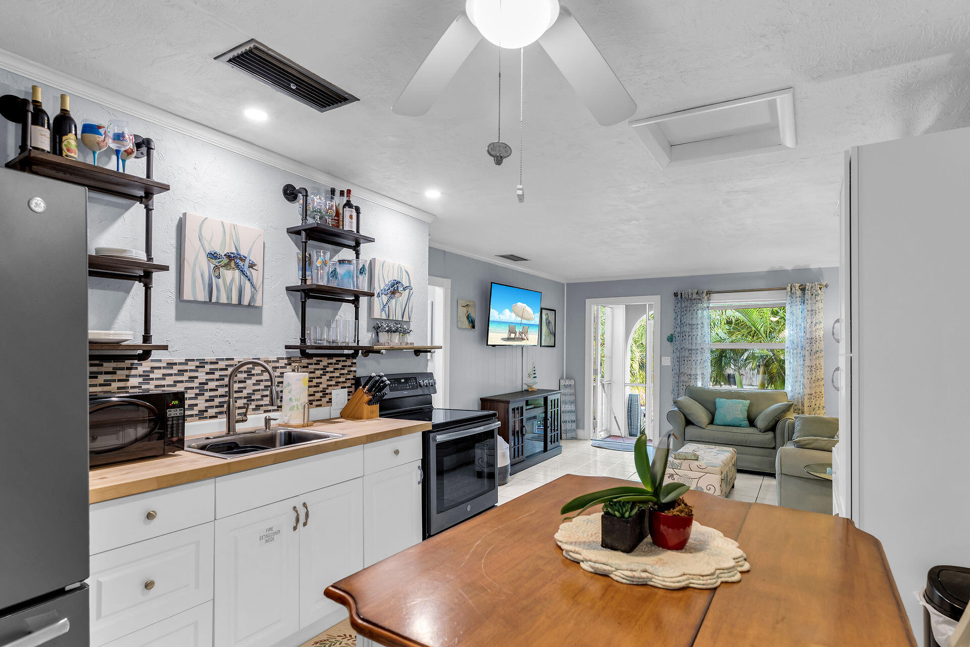 211 120 St Gulf, Unit B Marathon, FL 33050 - Photo 17 of 33 a kitchen with stainless steel appliances granite countertop a sink dishwasher a stove a dining table and chairs with wooden floor