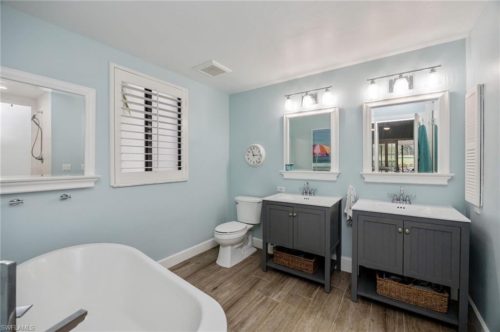 312 Bears Paw Trail Naples, FL 34105 - Photo 15 of 34 a bathroom with a toilet a sink a mirror and a window