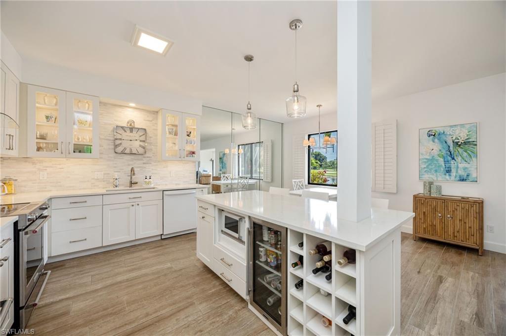 312 Bears Paw Trail Naples, FL 34105 - Photo 2 of 34 a large kitchen with stainless steel appliances a lot of counter space and wooden floor