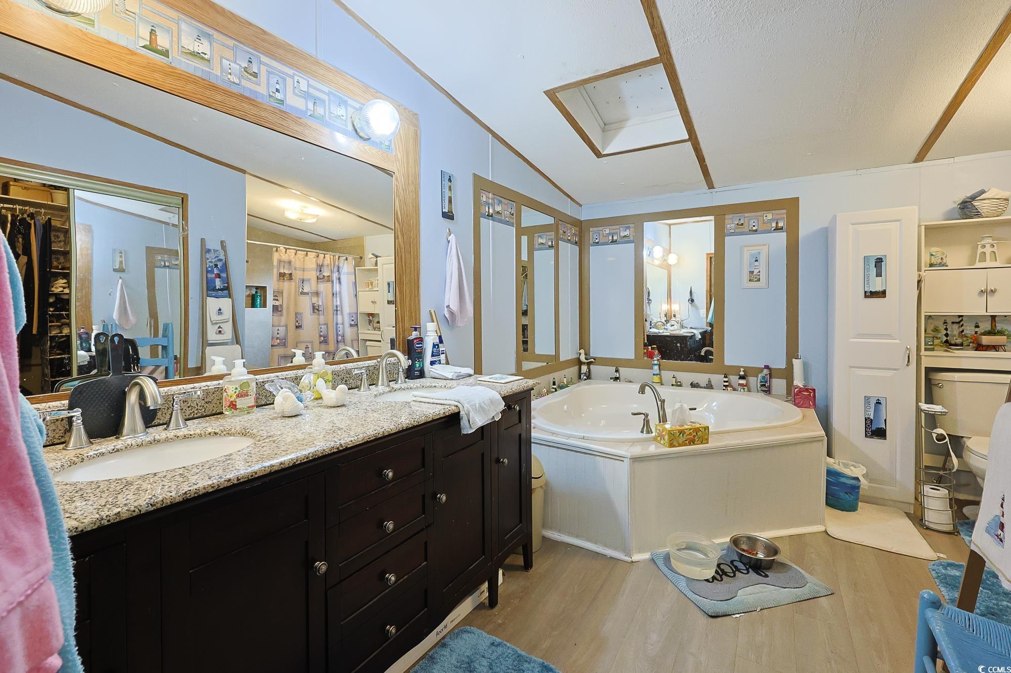 1522 Cove Lane Murrells Inlet, SC 29576 - Photo 14 of 33 Full bath featuring a garden tub, light wood-type flooring, double vanity, a shower with curtain, and vaulted ceiling