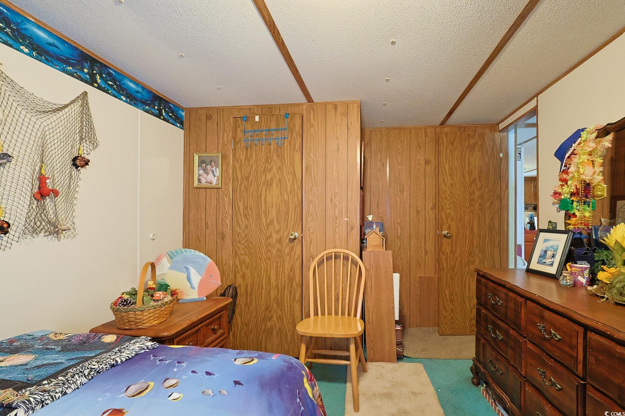 1522 Cove Lane Murrells Inlet, SC 29576 - Photo 24 of 33 Bedroom with carpet floors, wooden walls, and a textured ceiling