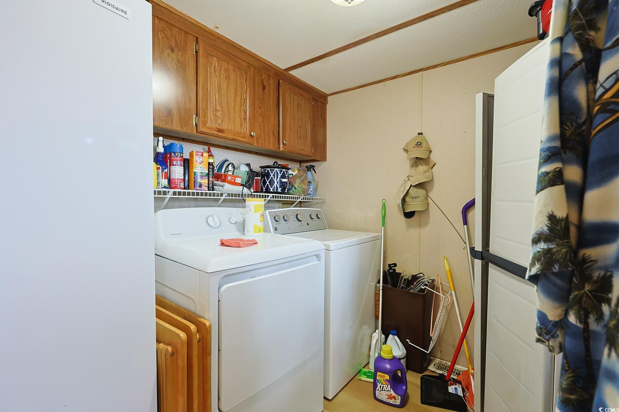 1522 Cove Lane Murrells Inlet, SC 29576 - Photo 25 of 33 Laundry room featuring cabinet space, washing machine and dryer, and light wood-style floors