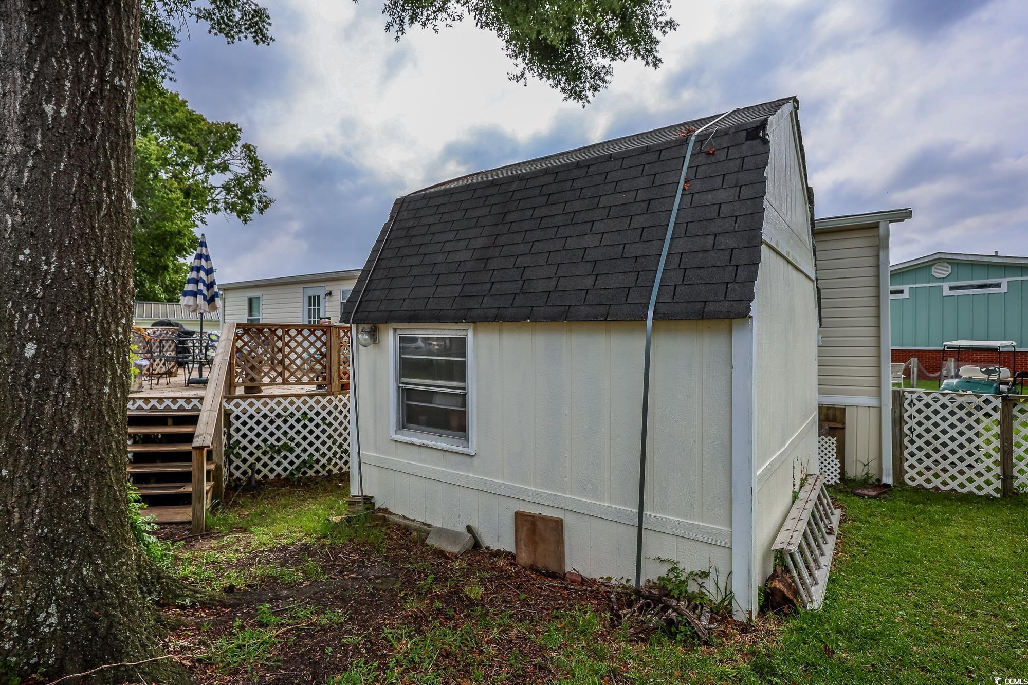 1522 Cove Lane Murrells Inlet, SC 29576 - Photo 28 of 33 View of side of property with roof with shingles, a wooden deck, an outdoor structure, a gambrel roof, and board and batten siding