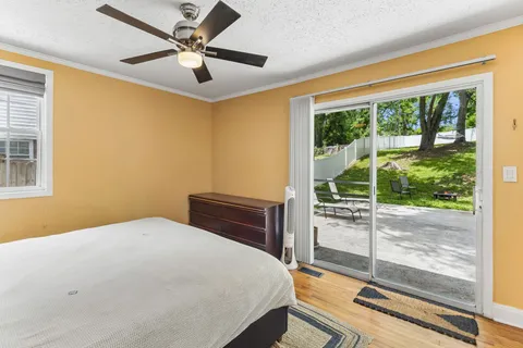a bedroom with a bed and a large window with the outer view