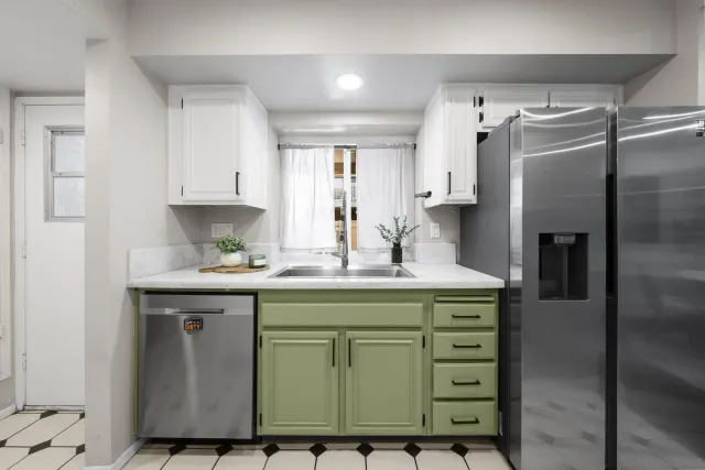 a kitchen with a sink a refrigerator and cabinets