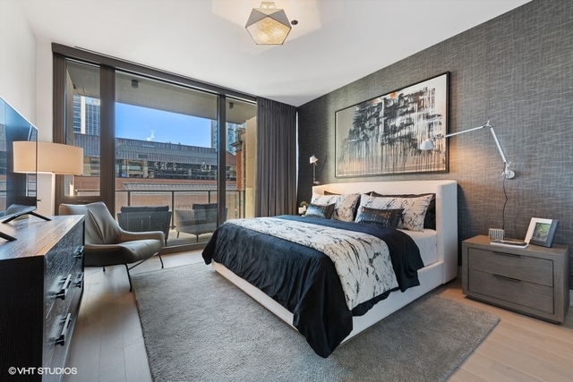 1550 North Clark Street, Unit 302 Chicago, IL 60610 - Photo 13 of 23 a spacious bedroom with a bed a couch and a large window