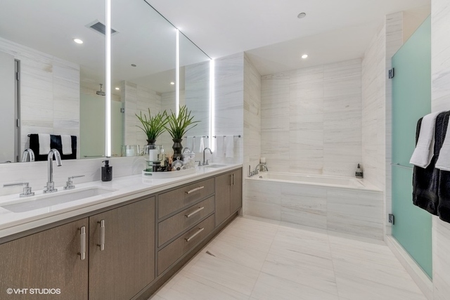 1550 North Clark Street, Unit 302 Chicago, IL 60610 - Photo 14 of 23 a bathroom with a double vanity sink a large mirror a shower and bathtub