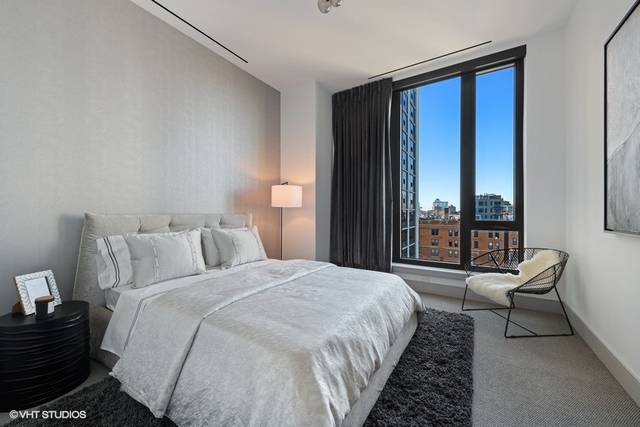 1550 North Clark Street, Unit 302 Chicago, IL 60610 - Photo 19 of 23 a spacious bedroom with a bed and a couch