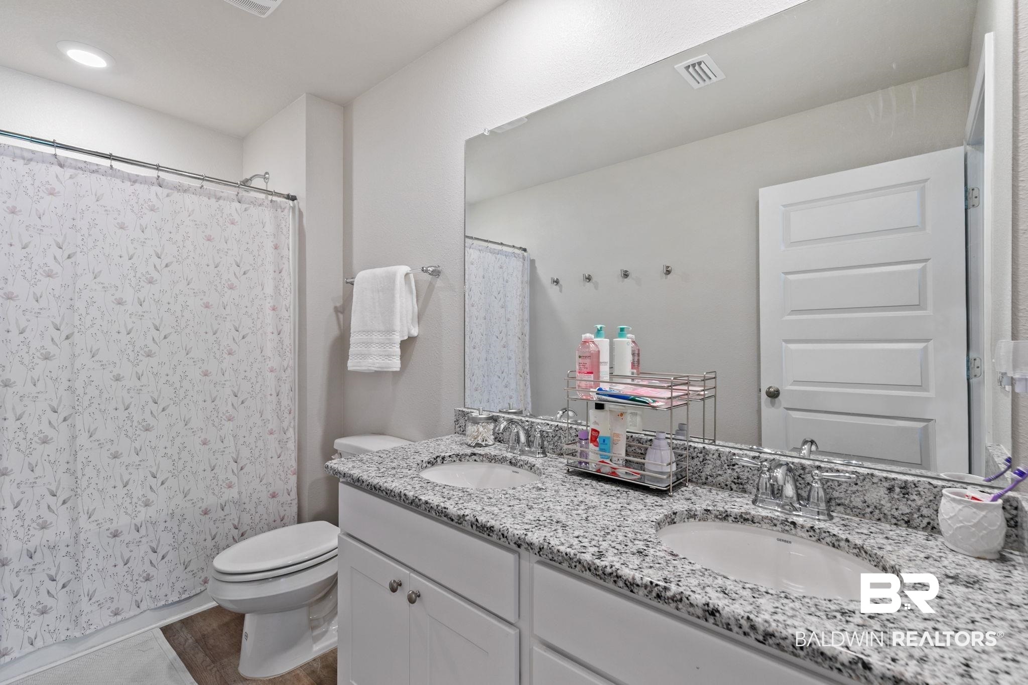 32234 Calder Court Daphne, AL 36527 - Photo 25 of 32 Full bath featuring double vanity, curtained shower, and light wood finished floors