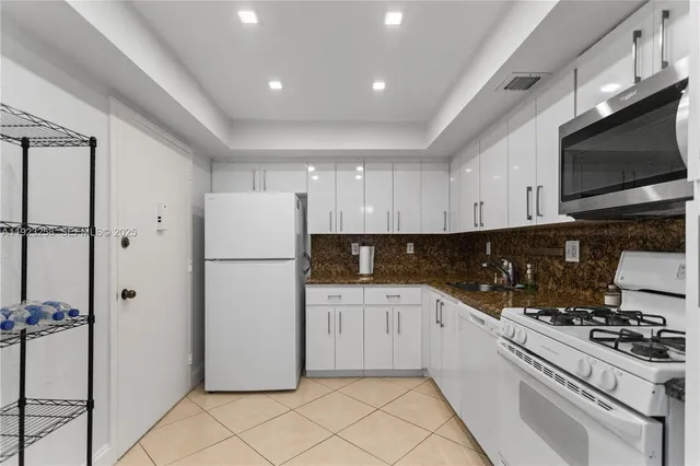 a kitchen with a refrigerator a stove top oven and cabinets