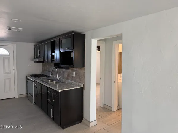 a bathroom with a granite countertop sink a mirror and a shower