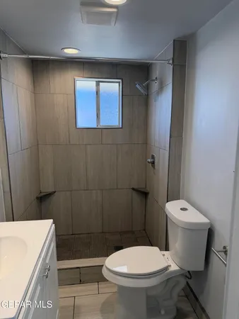 a white toilet sitting next to a bathroom sink and vanity