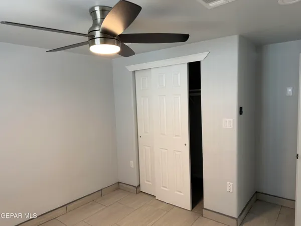 a view of an empty room with wall painting and a window