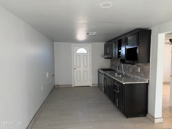 a kitchen with stainless steel appliances granite countertop a sink and a stove top oven